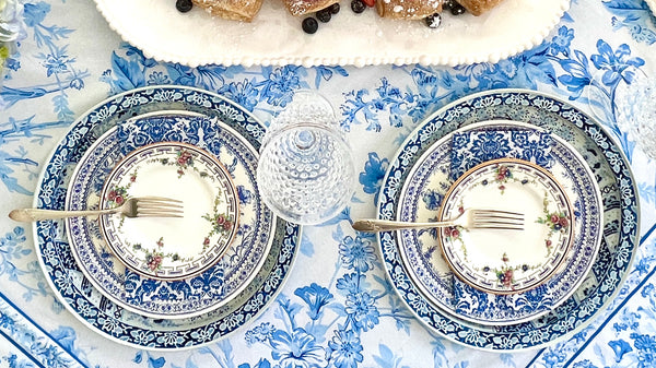 blue and white tabletop, featuring vintage round metal trays as chargers