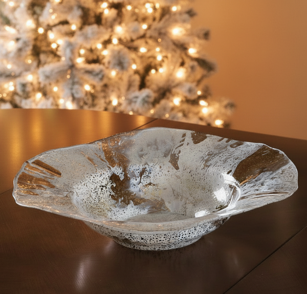 Decorative glass bowl on a table with a Christmas tree in the background