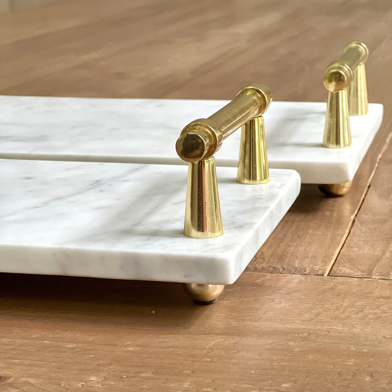 marble serving boards with gold handles and round feet