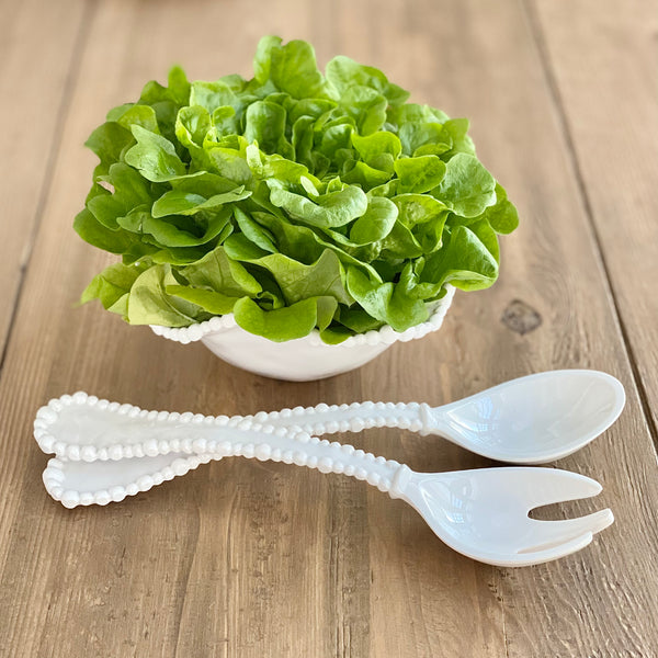 white melamine salad servers with pearl ball edge by Beatriz Ball next to a bowl of lettuce