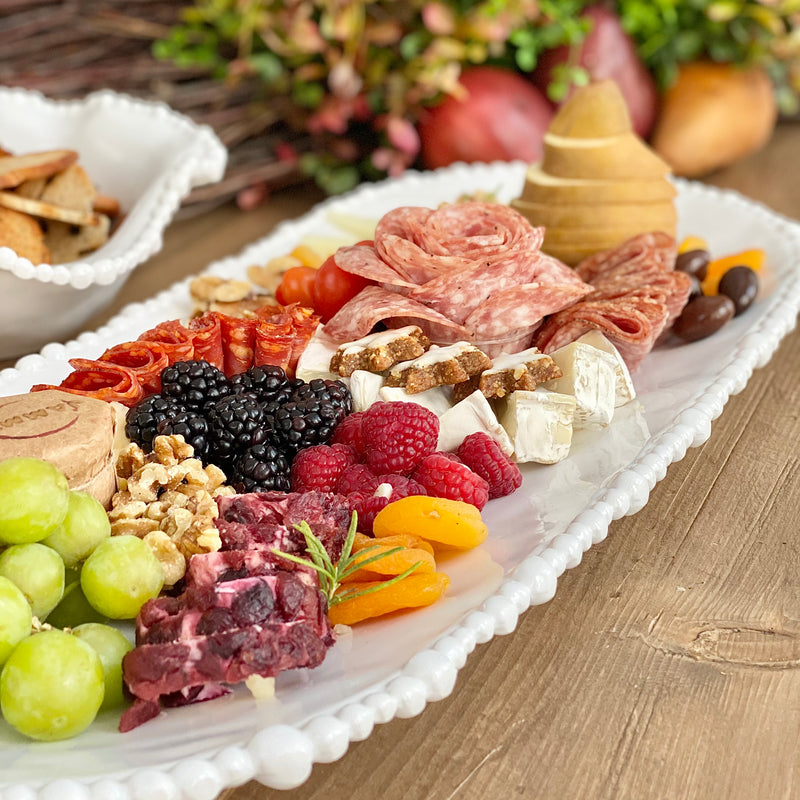 Large oval white melamine tray with elegant pearl edge by Beatriz Ball, showcasing an array of charcuterie.