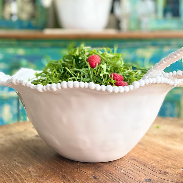 Pretty heavy weight white melamine salad bowl and servers with pearl ball rim by Beatriz Ball, shown on a wood table and filled with salad.