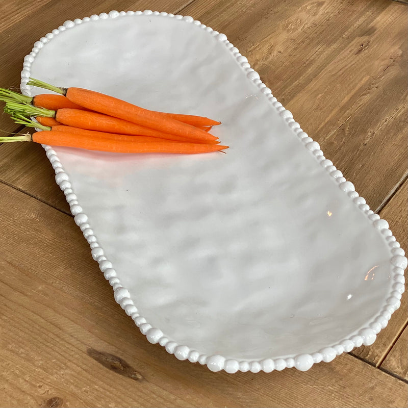 Large oval white melamine tray with elegant pearl edge by Beatriz Ball, shown with carrots.