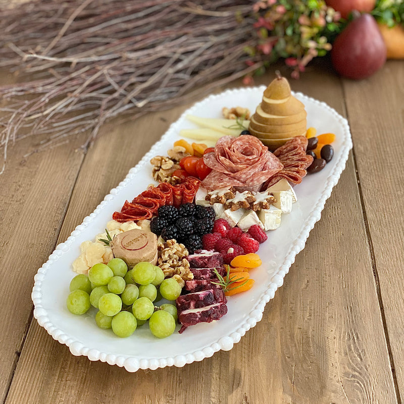 Large oval white melamine tray with elegant pearl edge by Beatriz Ball, showcasing an array of charcuterie.