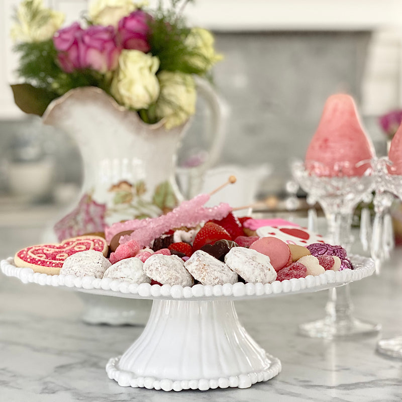 Pretty Beatriz Ball white melamine pedestal cake plate with cookies and fruit on top.